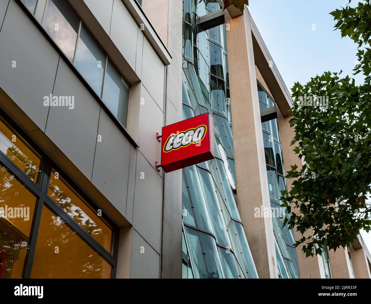 LEGO sign on a building exterior in the city. Logo of the Danish toy manufacturer on a facade. Advertising in a shopping street. Looking up to it. Stock Photo