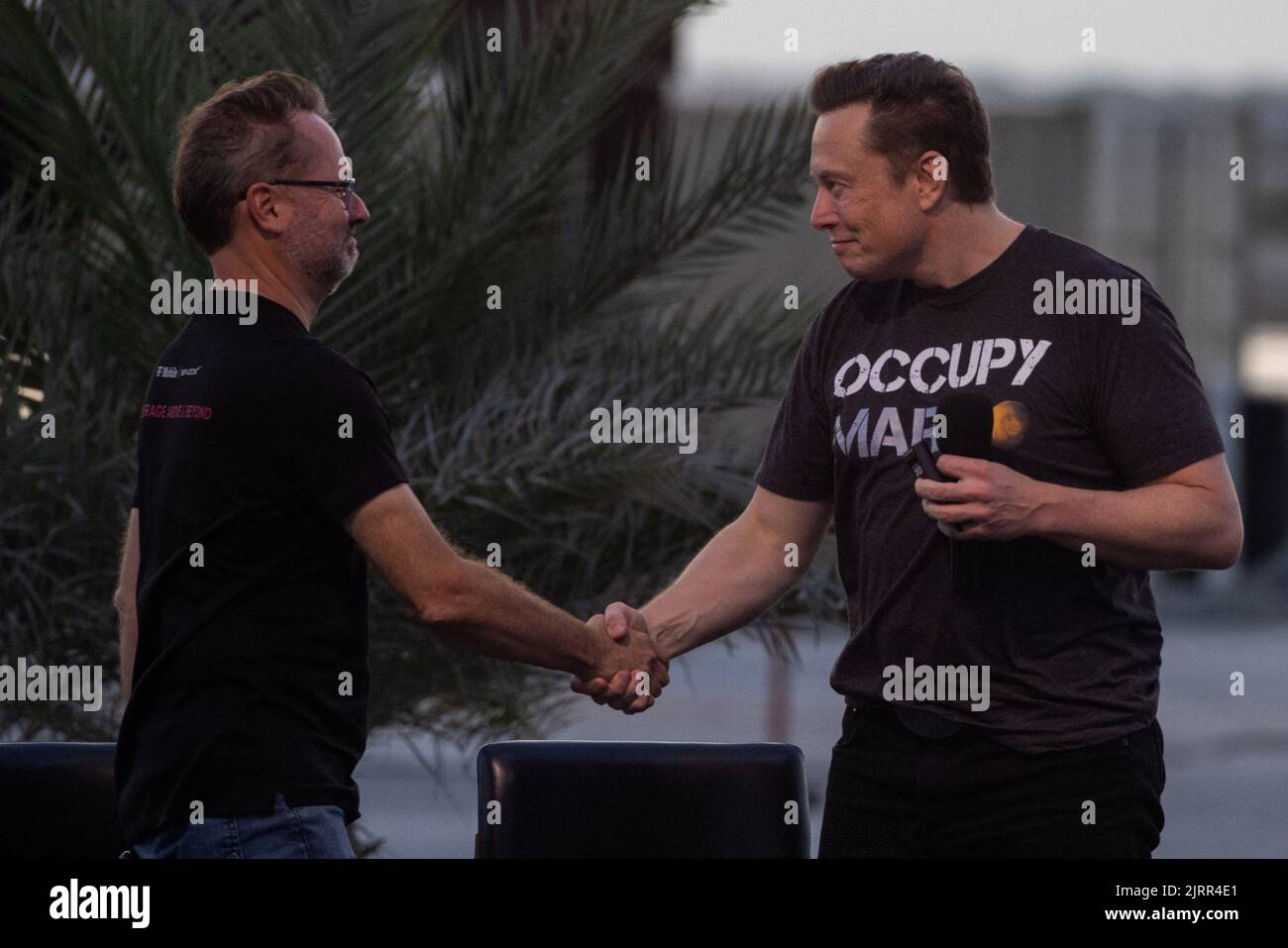 SpaceX Chief Engineer Elon Musk shakes hands with T-Mobile CEO Mike Sievert after a joint news conference at the SpaceX Starbase, in Brownsville, Texas, U.S., August 25, 2022. REUTERS/Adrees Latif Stock Photo