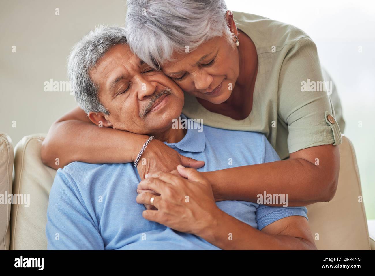 Sad or unhappy senior couple hug, comfort or support in a living room at home. Elderly husband suffering from depression problem after retirement Stock Photo