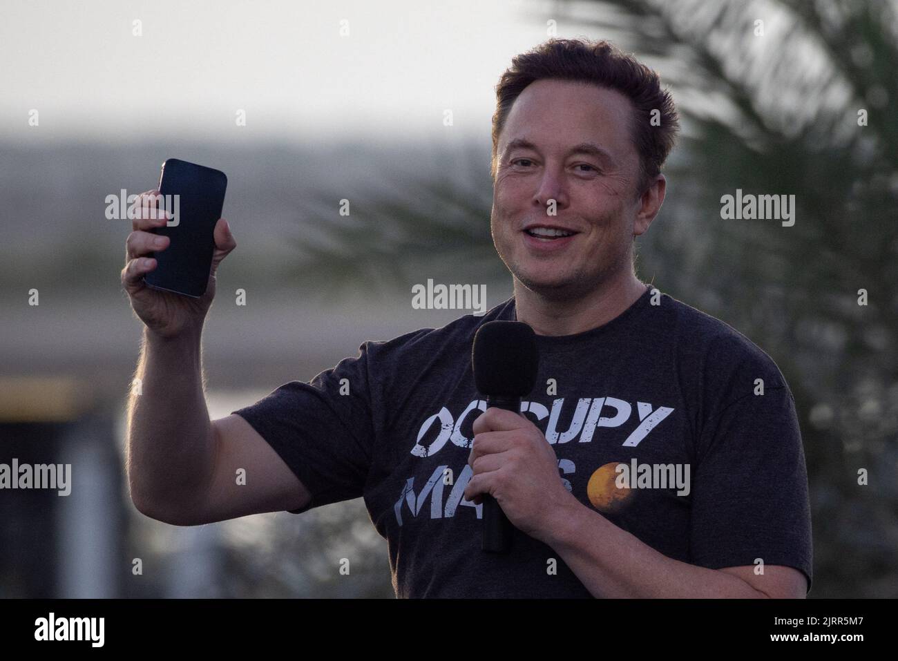 SpaceX Chief Engineer Elon Musk raises his phone during a joint news conference with T-Mobile CEO Mike Sievert at the SpaceX Starbase, in Brownsville, Texas, U.S., August 25, 2022. REUTERS/Adrees Latif Stock Photo