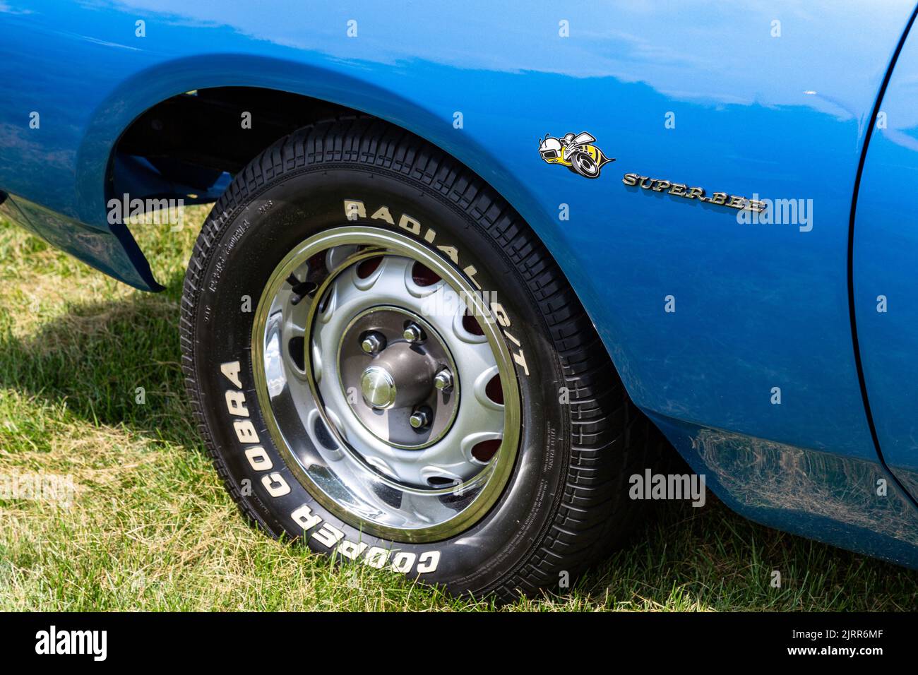 A Cooper Cobra Radial GT tire mounted on a vintage blue Dodge Super Bee. Stock Photo