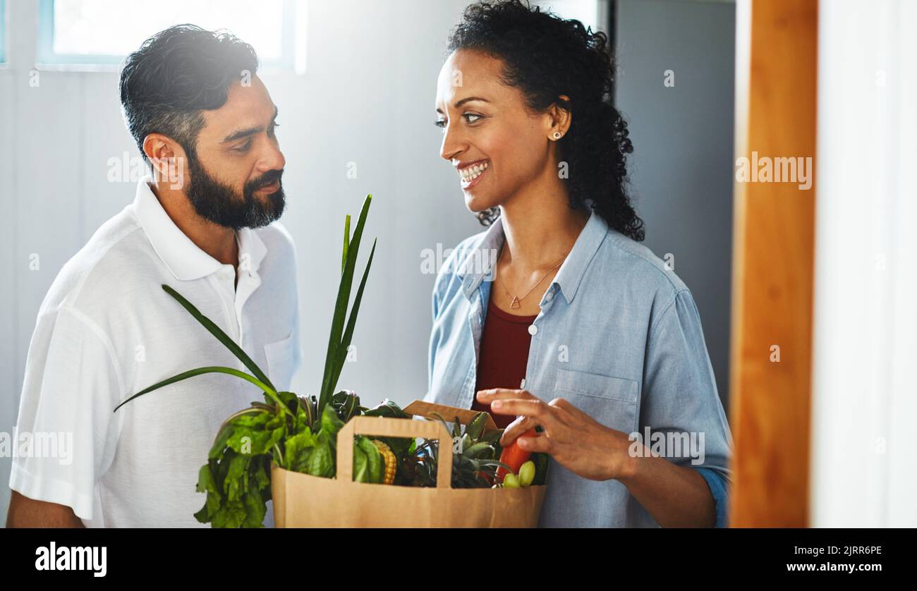 Honey, Im home. a happy person holding a shopping bag full of healthy vegetables. Stock Photo