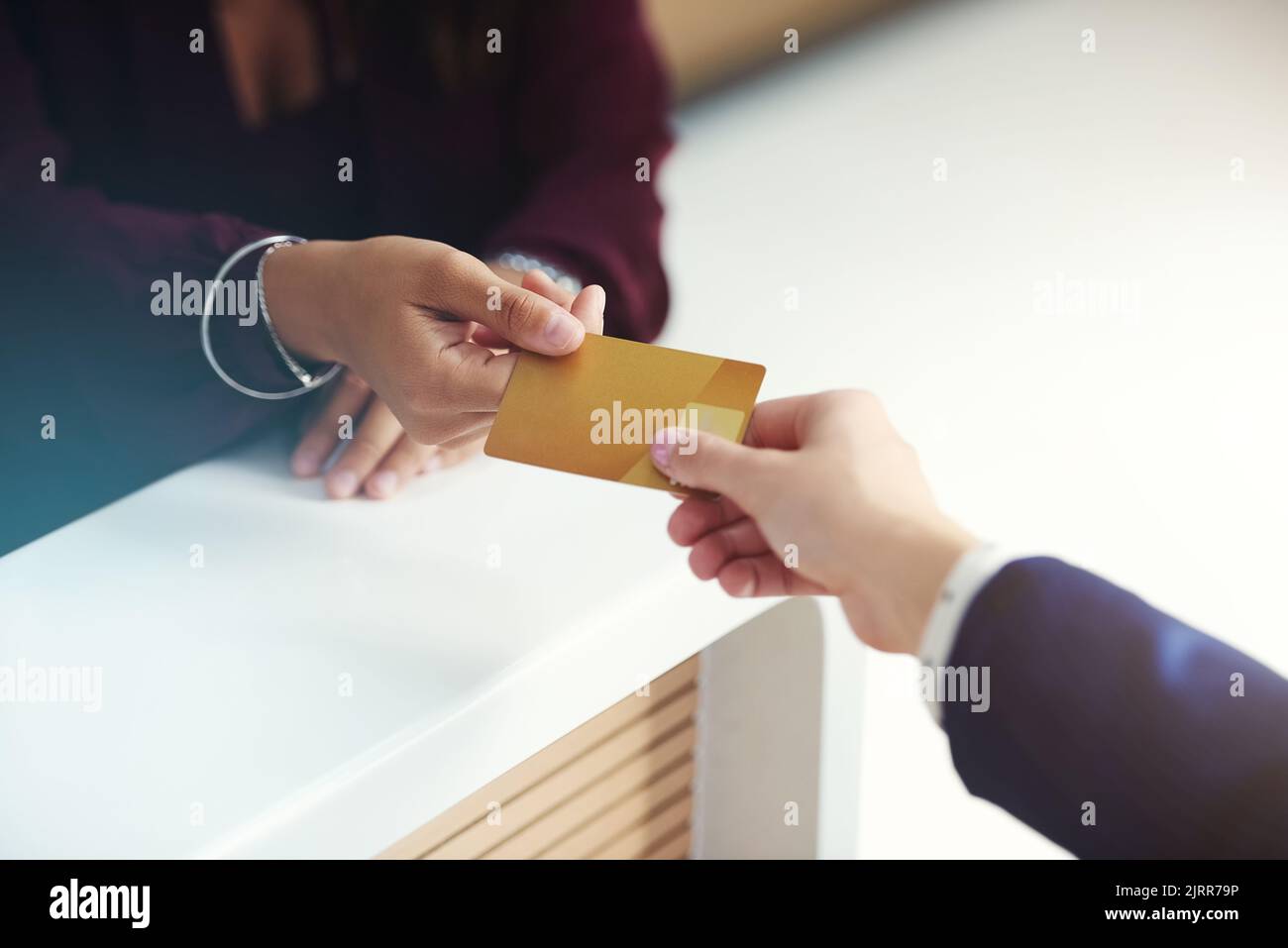 Here you go. an unrecognisable person handing over a credit card for payment. Stock Photo