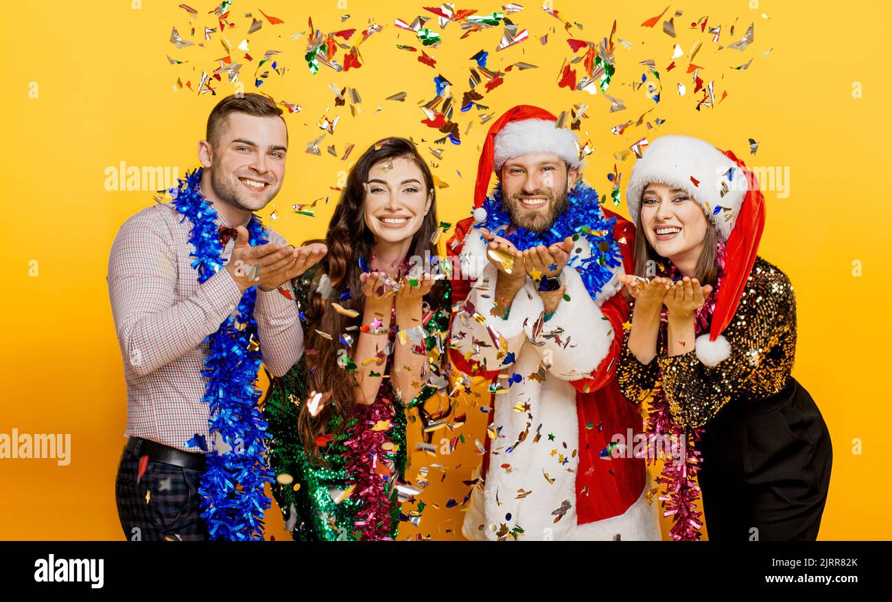 Confetti party. A group of friends in New Year's tinsel and a santa