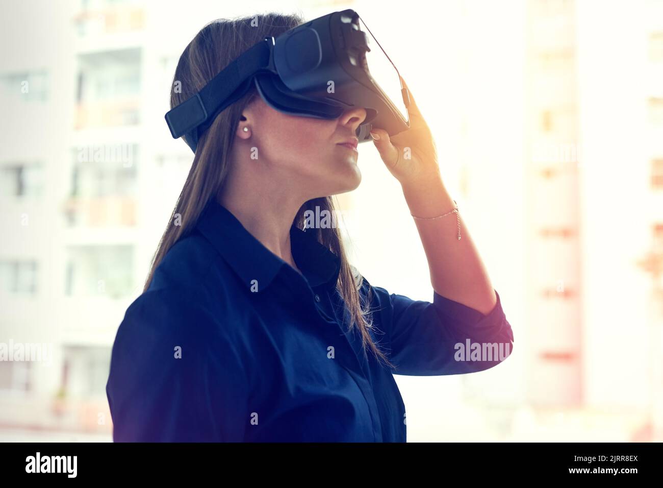 Seeing is believing. a young businesswoman wearing a VR headset in an office. Stock Photo