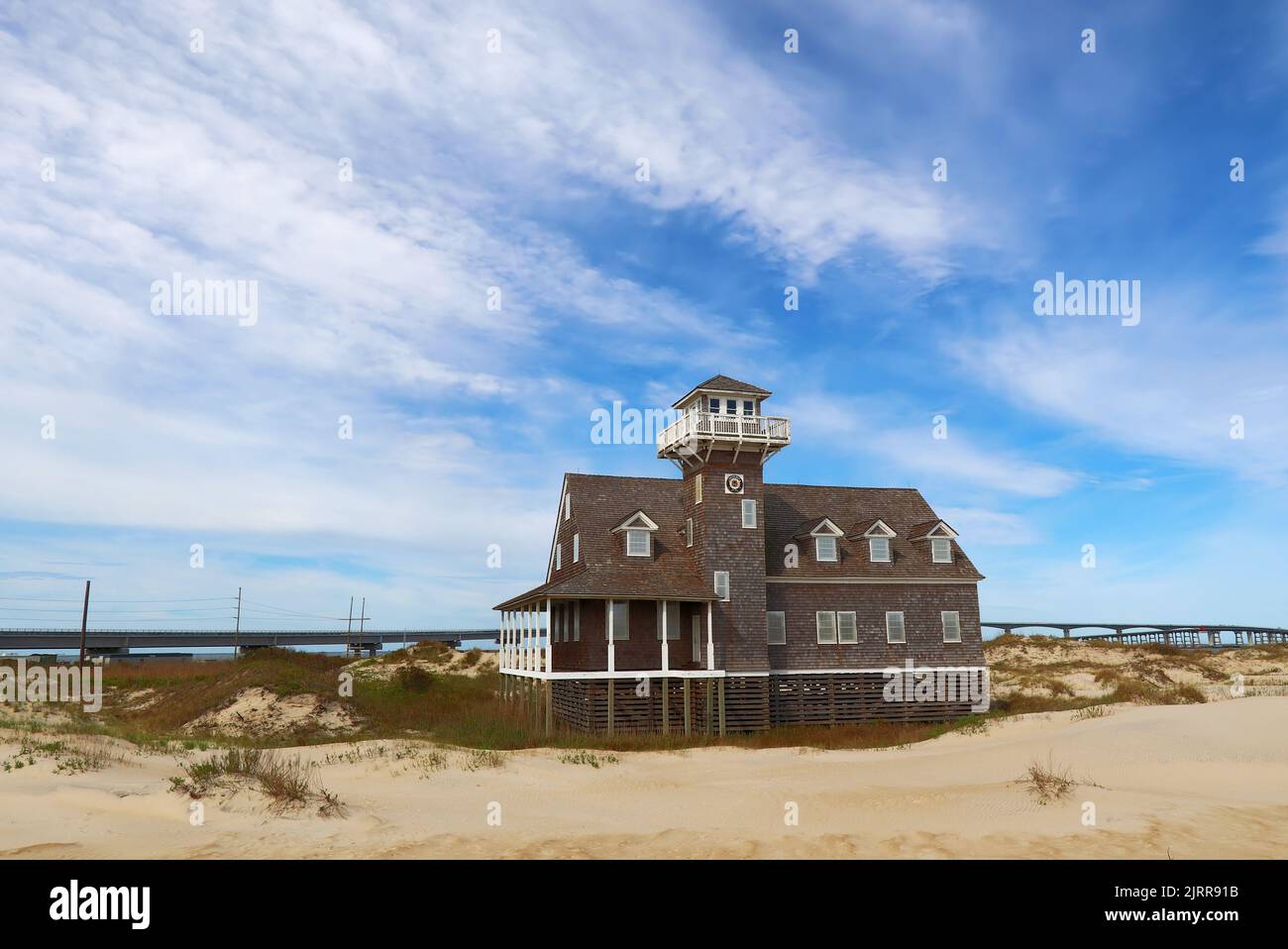 Historic Oregon Inlet life-saving station on Pea Island near Rodanthe, on the outer banks of North Carolina against a dramatic blue sky Stock Photo