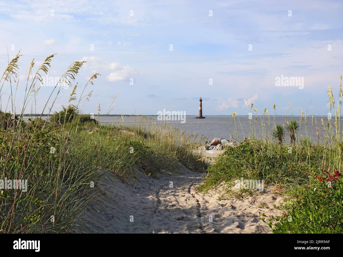 Lighthouse Inlet Heritage Preserve at the northern end of Folly Island, South Carolina with the Morris Island Lighthouse in the background Stock Photo