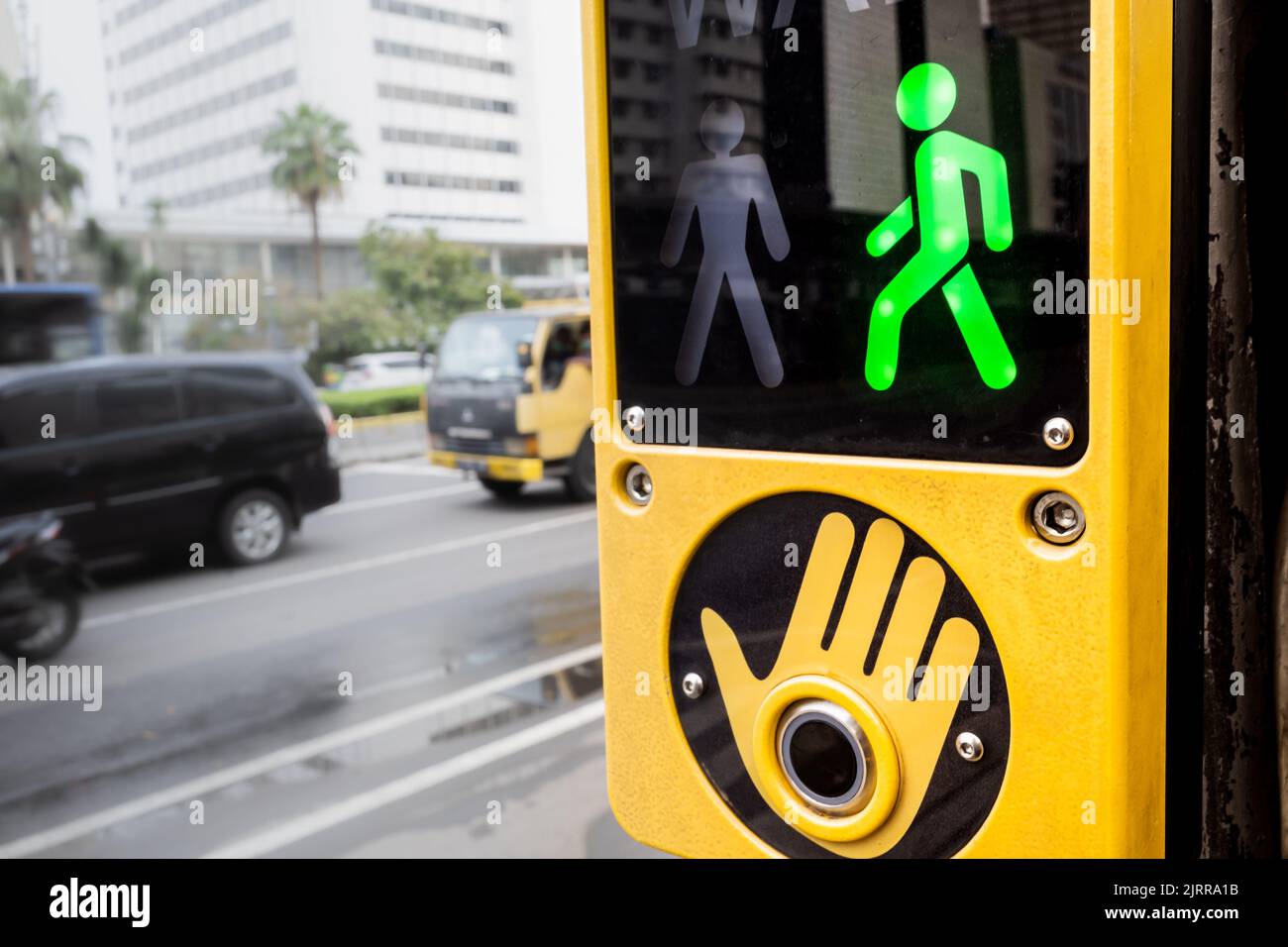 Walk signal sign located at crosswalk area on a busy city street Stock ...