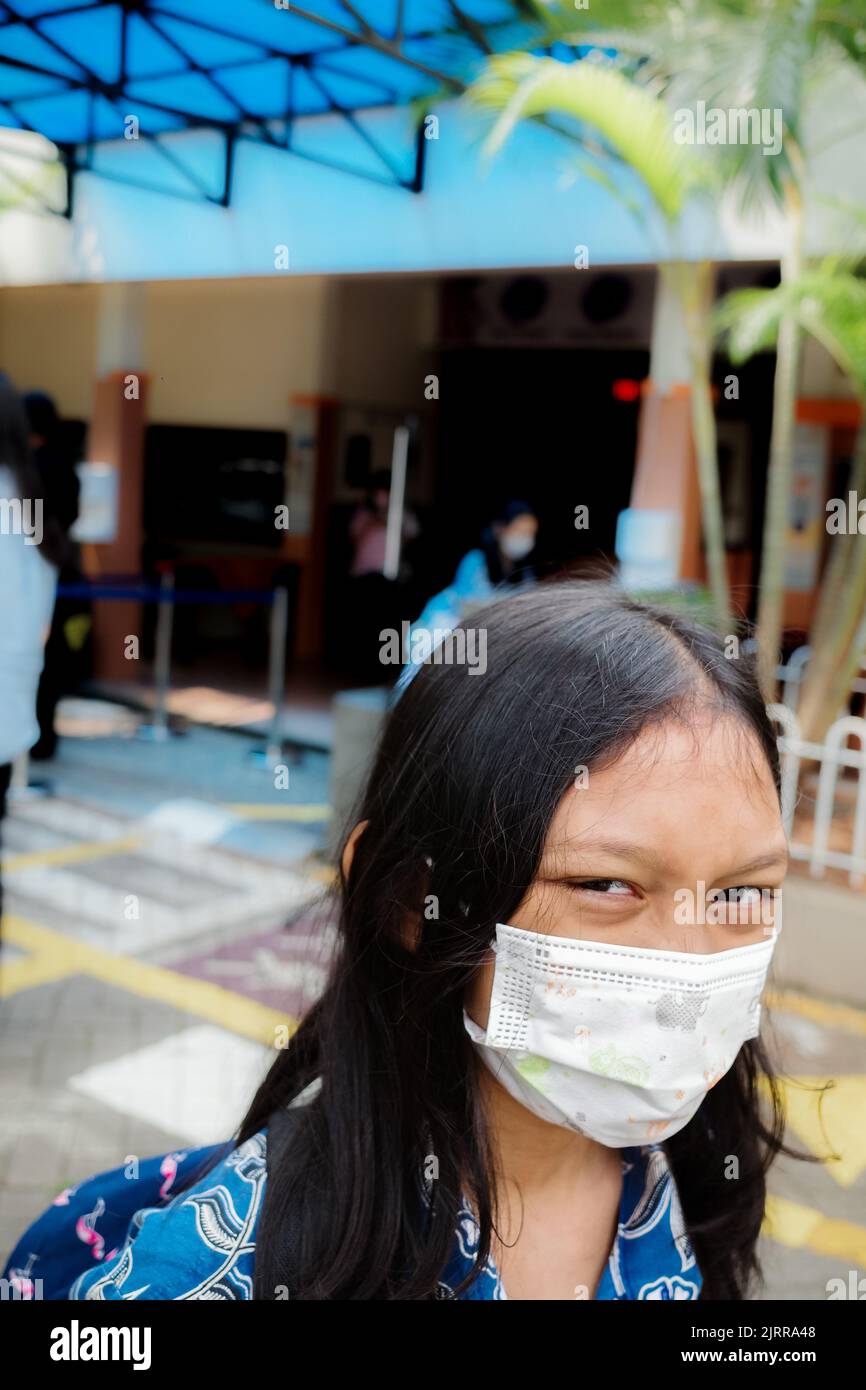 Southeast Asian schoolgirl wearing face mask back to school again after covid pandemic Stock Photo