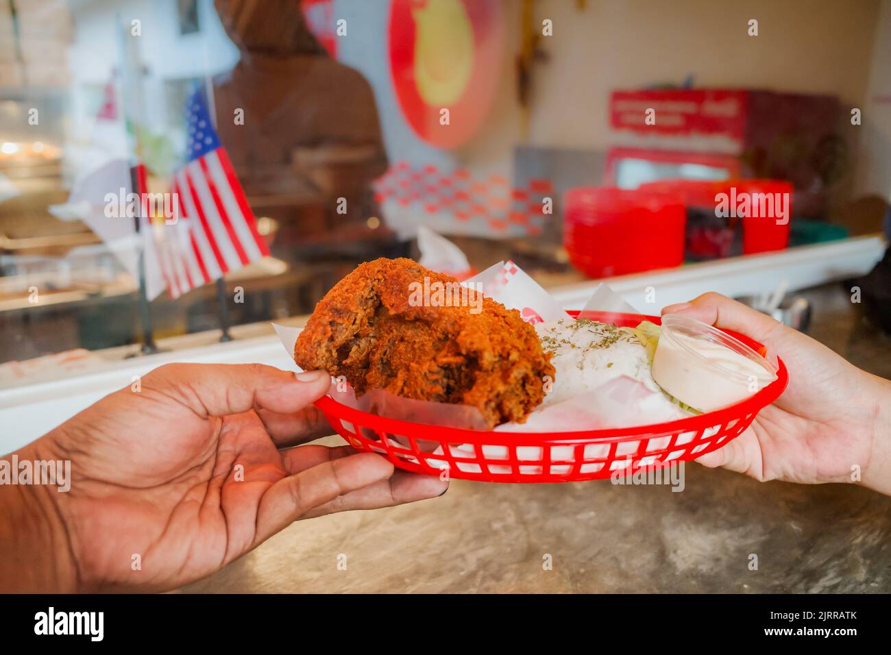 Man hand over a plate of spicy lunch meal to female customer at a