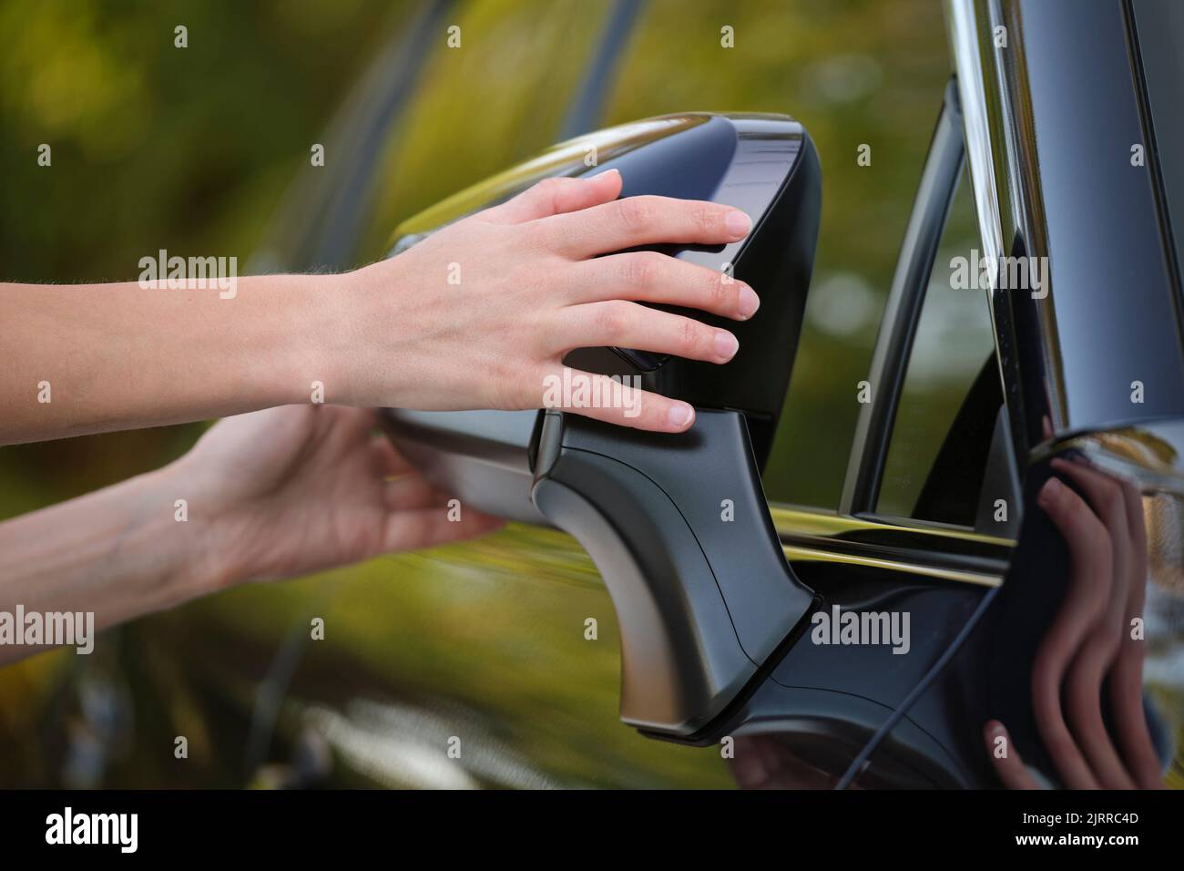 Driver hands adjusting side view mirror of a car Stock Photo Alamy