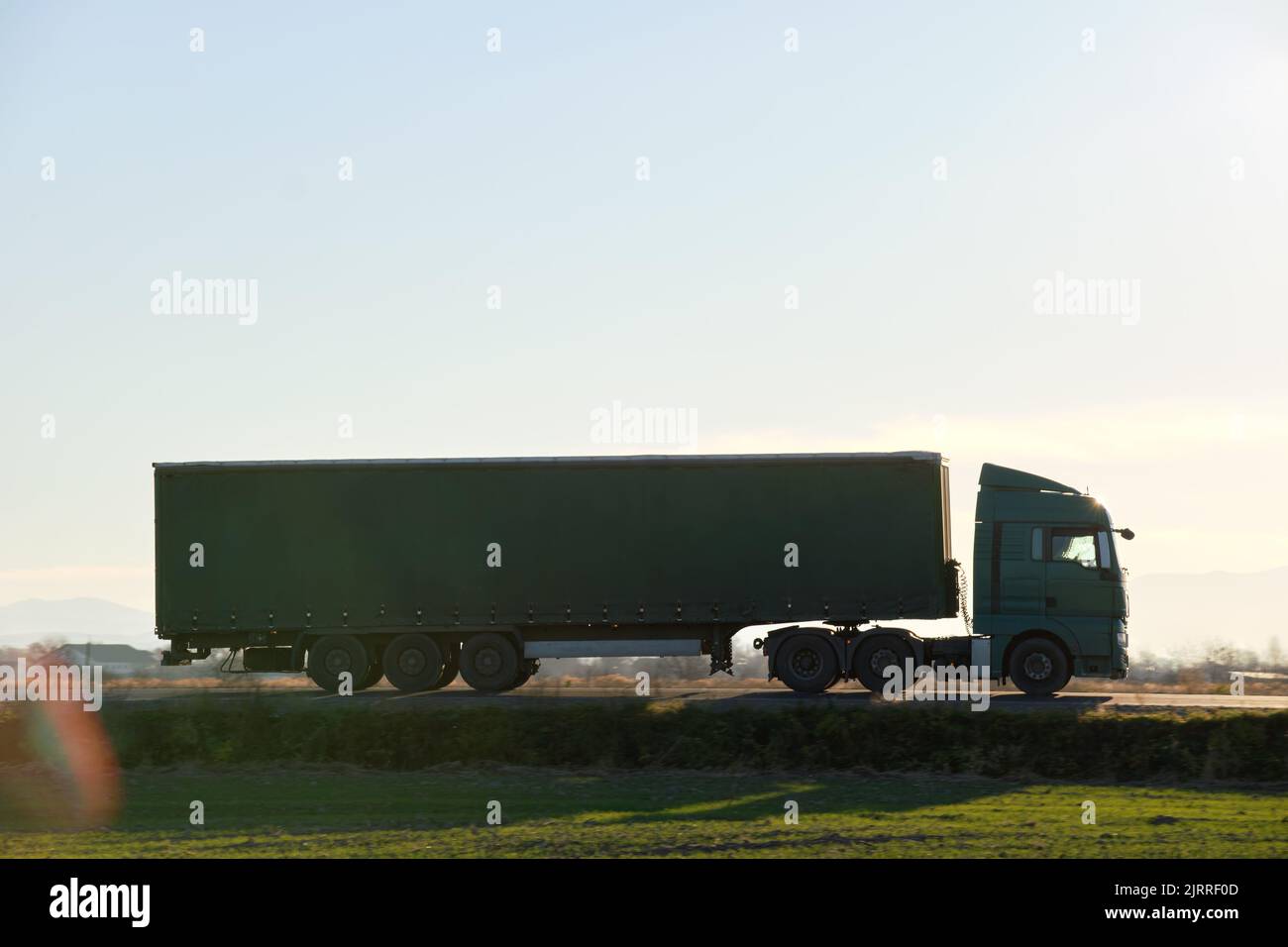 Semitruck with cargo trailer driving on highway hauling goods in