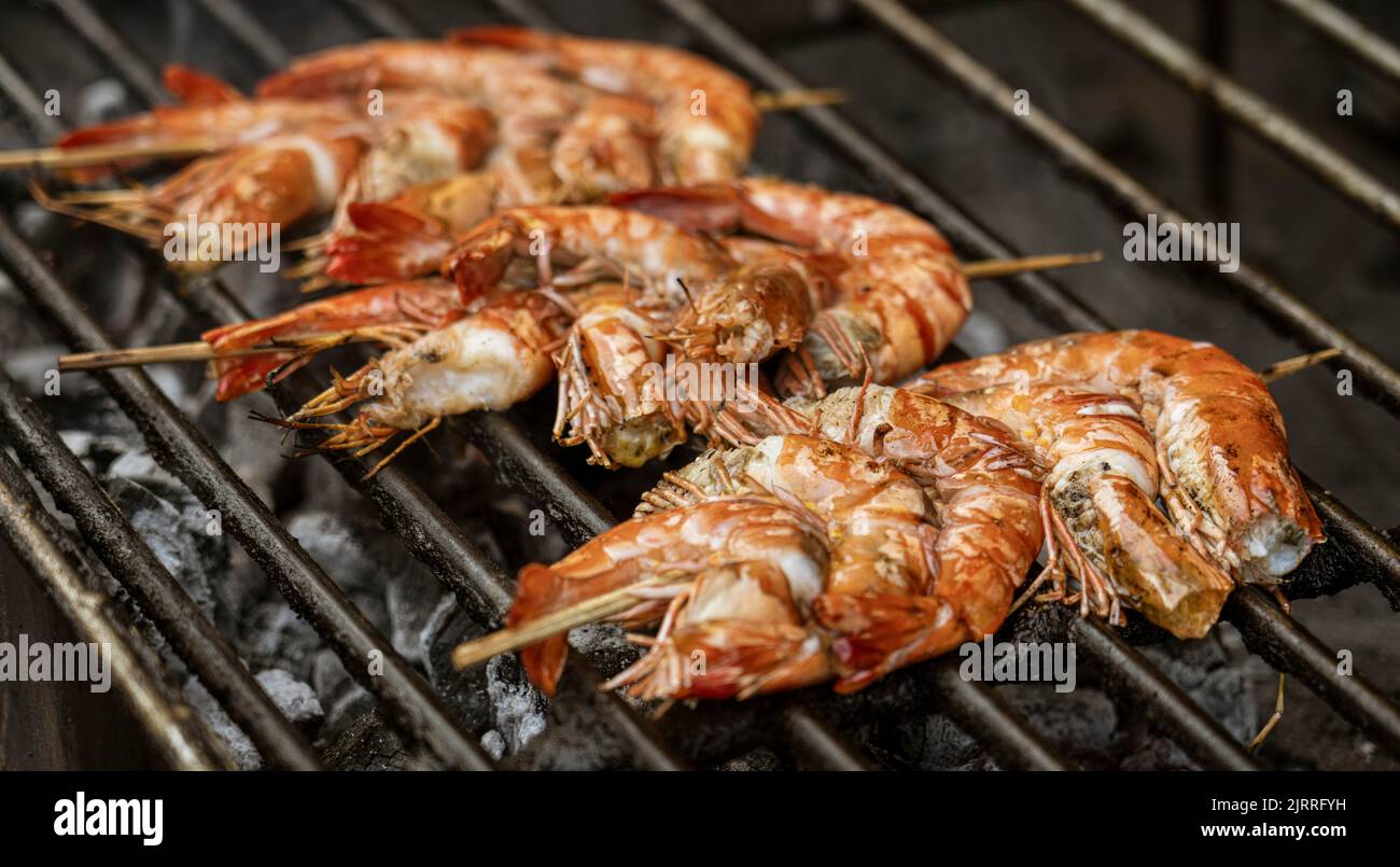 Java, Indonesia, June 13, 2022 - Shrimp on a skewer on a BBQ. Stock Photo