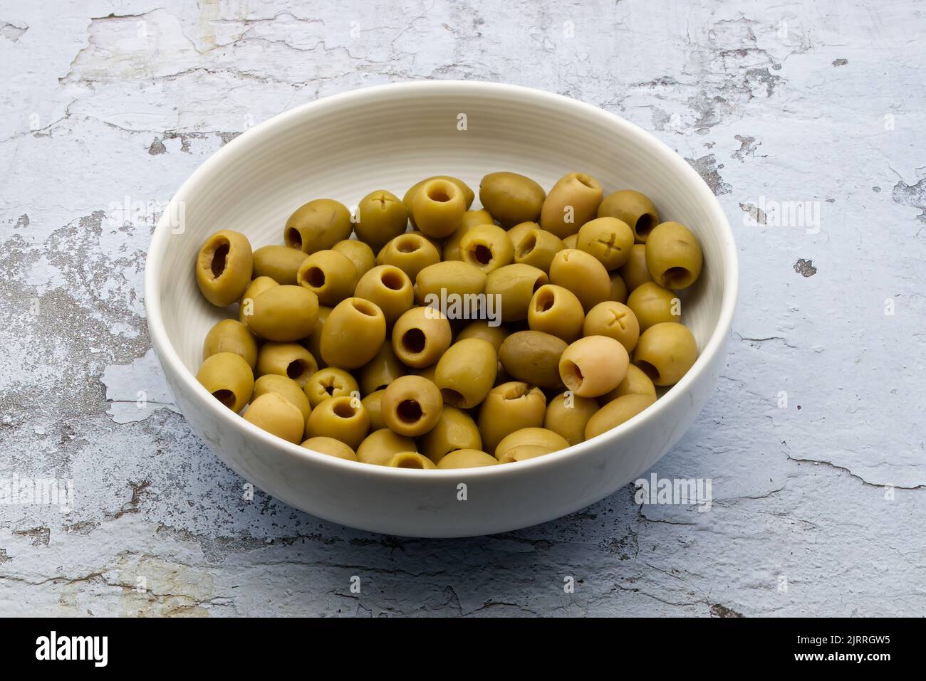 Pitted green olives in a white ceramic bowl Stock Photo Alamy