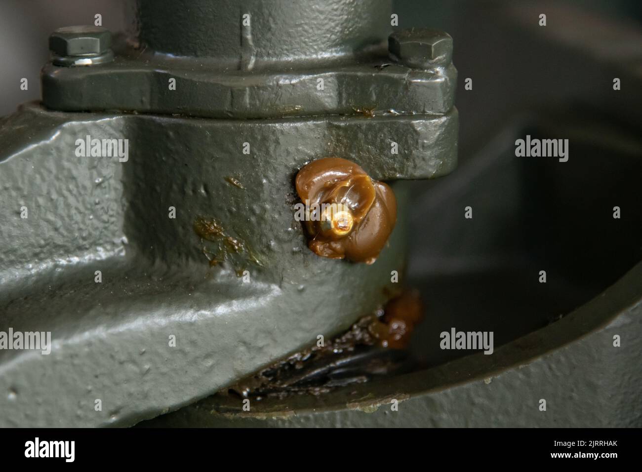 Grease nipple on industrial equipment with excessive grease lubricant Stock Photo