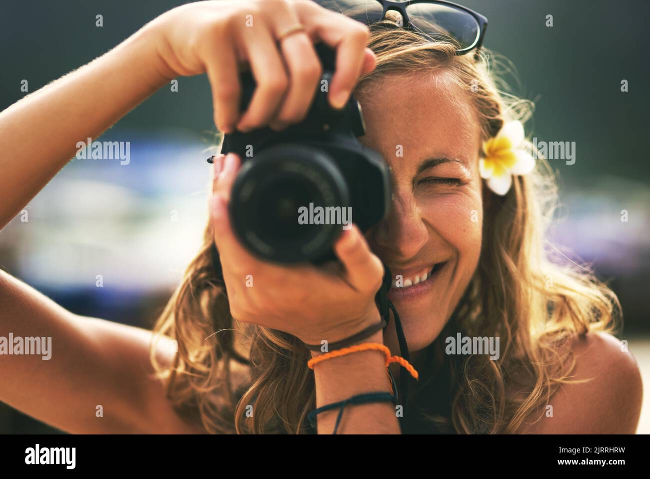 My profession Im a memory collector. Portrait of a young woman taking photos with her camera at the beach. Stock Photo
