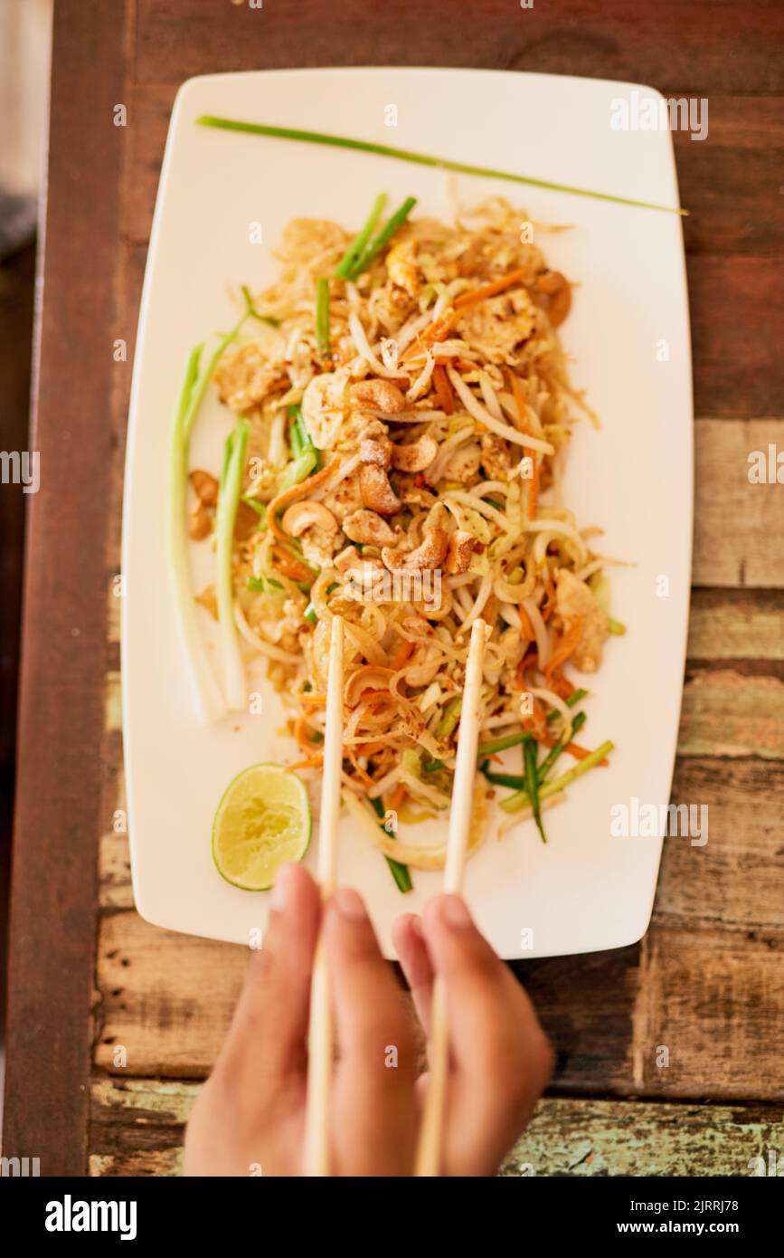 Pad thai anyone. a person eating a bowl of pad thai in a restaurant in Thailand. Stock Photo