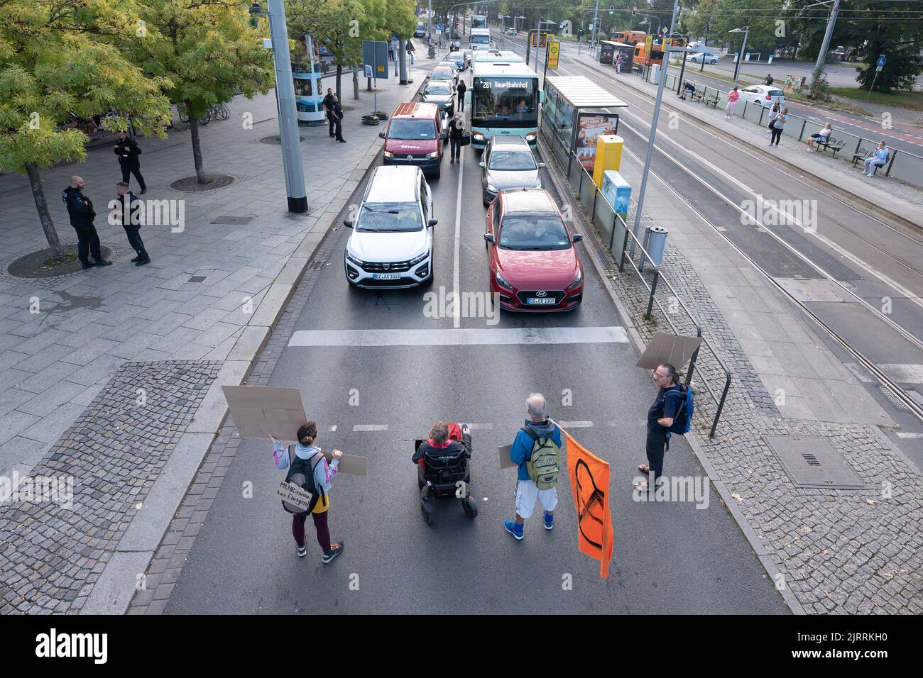 Dresden, Germany. 26th Aug, 2022. Environmental activists stand with their banners in front of stationary cars during a demonstration on the roadway at a traffic light intersection at Albertplatz. Credit: Sebastian Kahnert/dpa/Alamy Live News Stock Photo