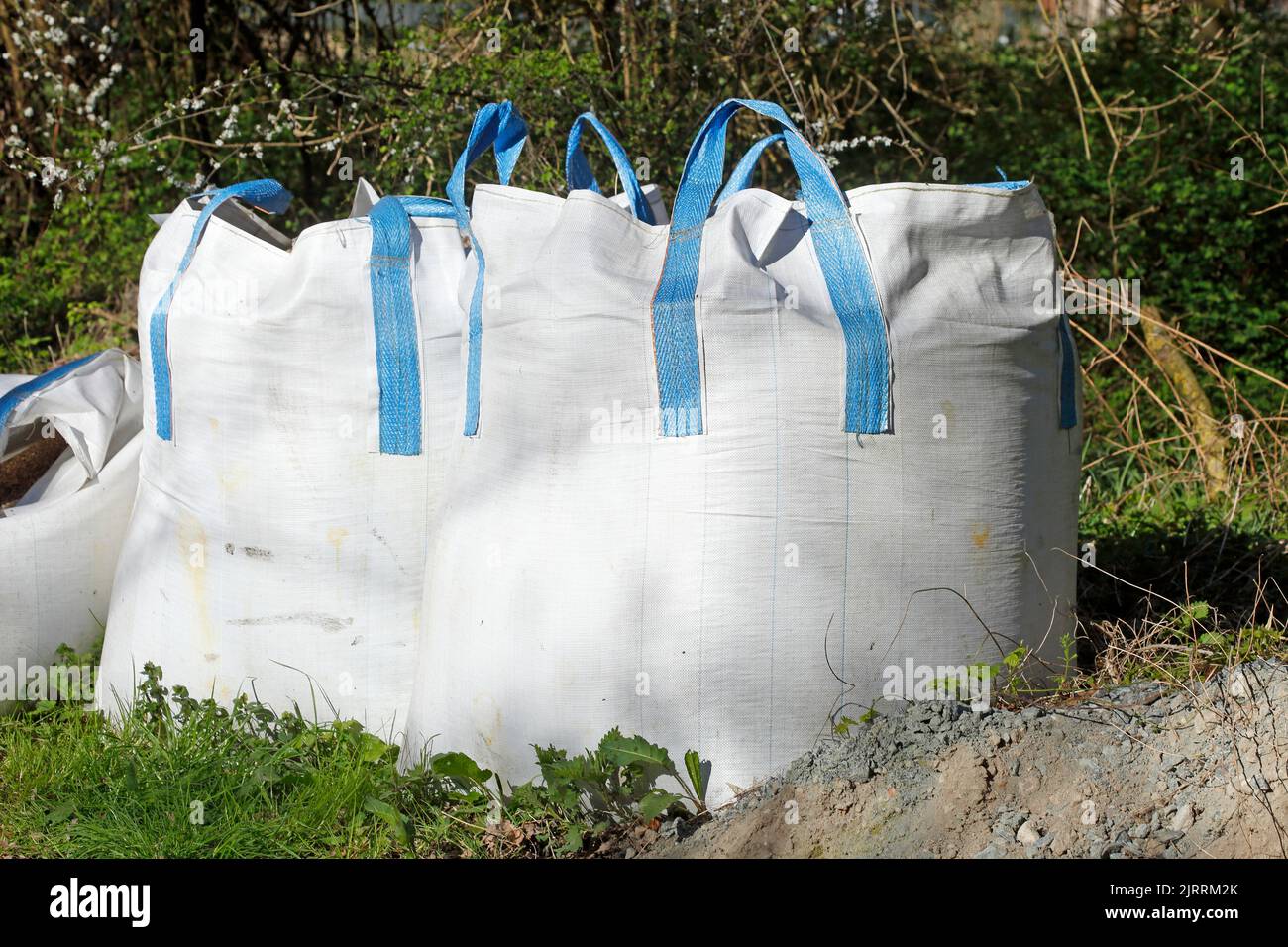 The white big bulk bags full of potting soil on the grass Stock Photo