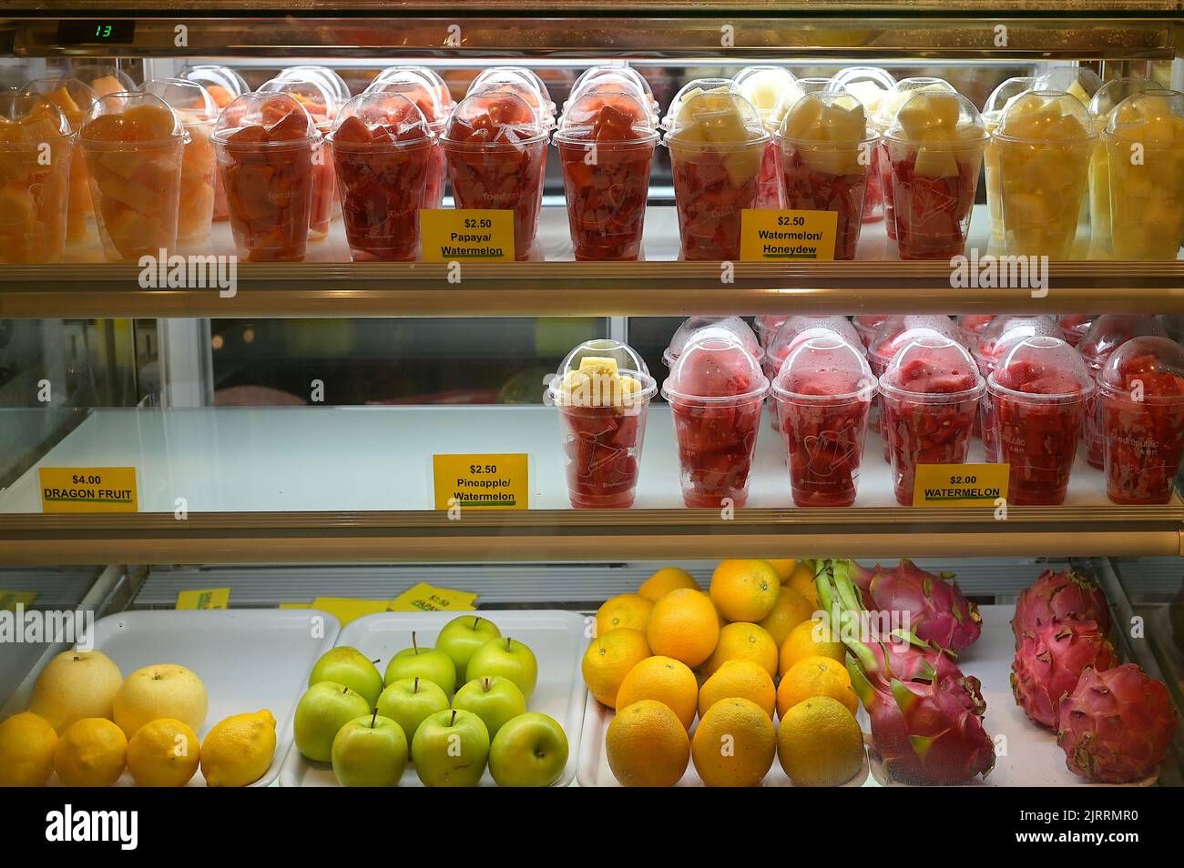 A selection of cut tropical fruits in plastic cups and other whole