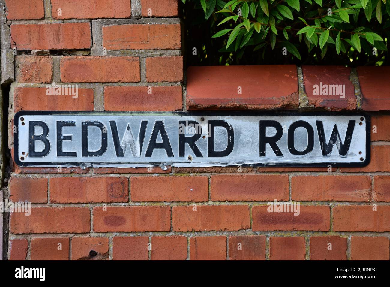 A faded street name sign for Bedward Row mounted on a red brick wall Stock Photo