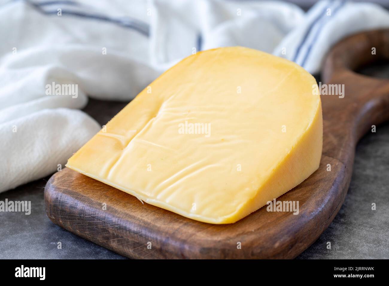 Yellow gouda cheese. Hard Dutch gouda cheese, on dark background. close