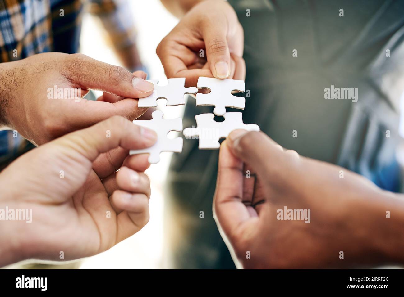 Theyre all a part of the bigger picture. a work group connecting pieces of a puzzle. Stock Photo