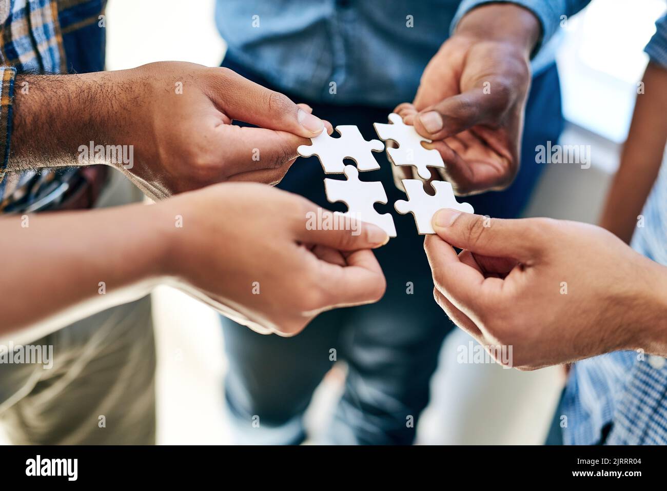 Equally responsible for finding a solution. a work group connecting pieces of a puzzle. Stock Photo