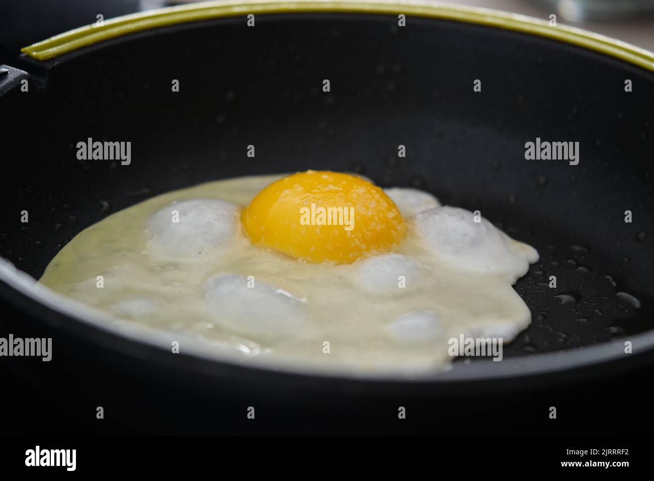 Frying egg in a cooking pan. Stock Photo