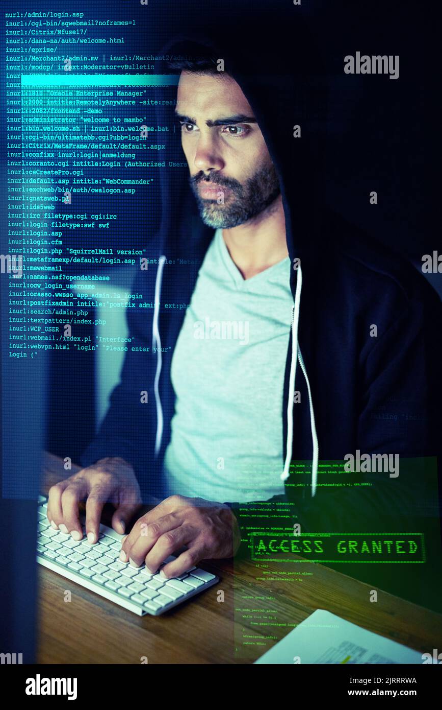 Up to no good online. a focussed computer hacker using a computer in the dark. Stock Photo