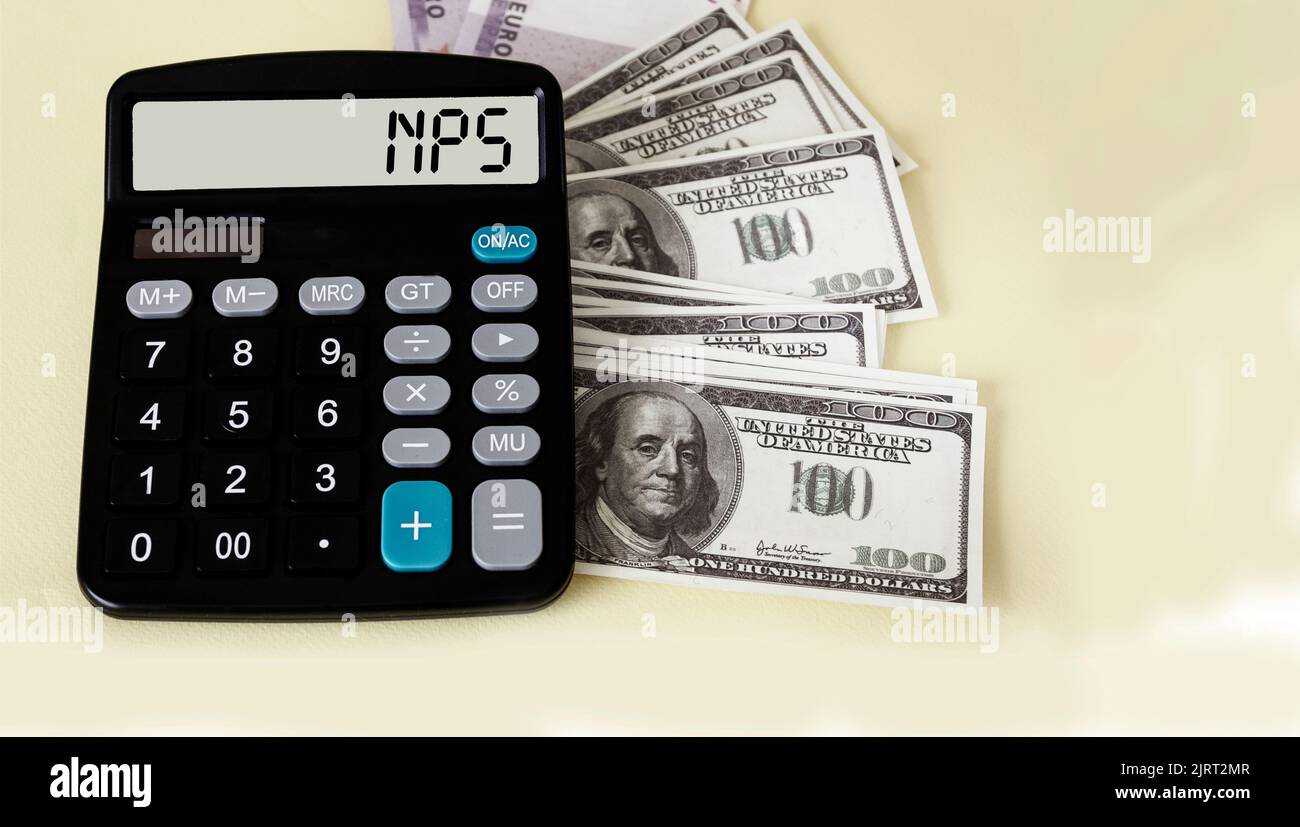 NPS Net Promoter Score - abbreviation on calculator display against euro and dollar banknotes background. Business and finance concept Stock Photo