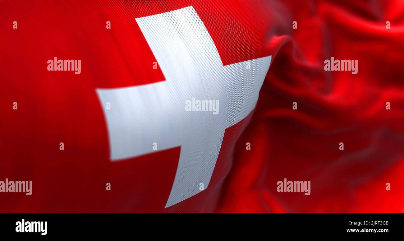 Close-up view of the swiss national flag waving in the wind. Switzerland is a landlocked country located in Europe. Fabric textured background. Select Stock Photo