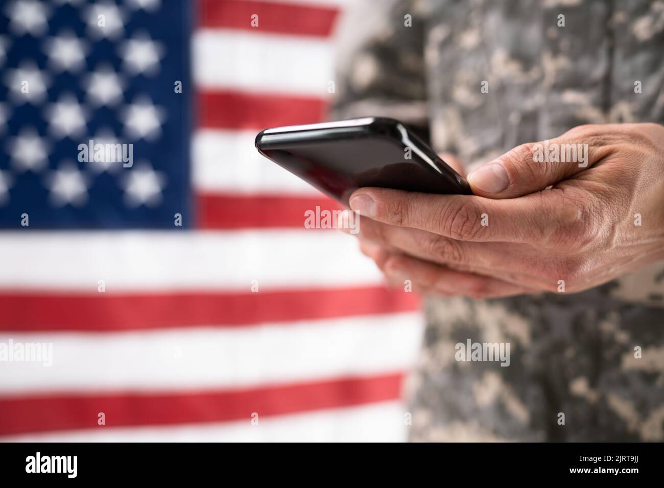 Soldier Holding Mobile Phone. Military War Espionage Stock Photo