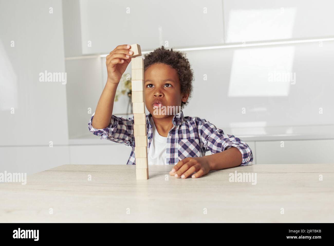 Curious kid little boy playing with wooden toys at home Stock Photo