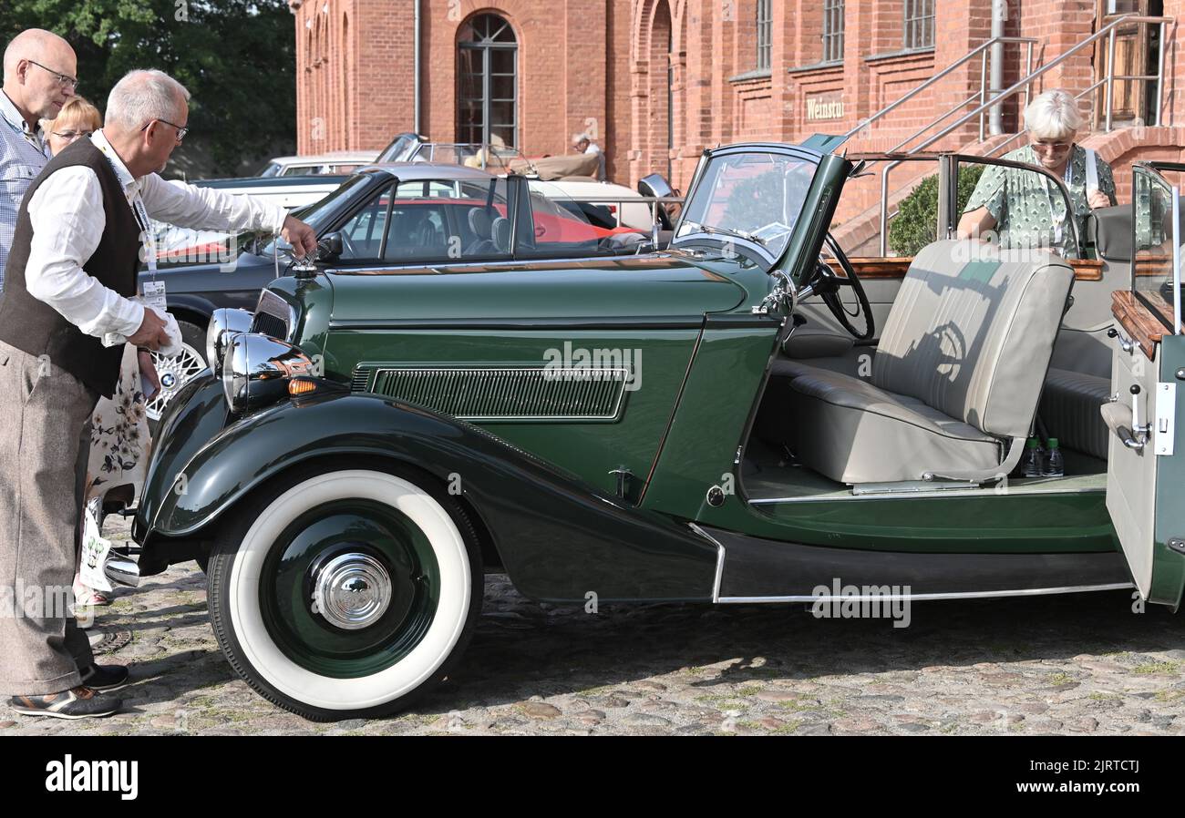 Nauen, Germany. 26th Aug, 2022. The driver of a Wanderer W50 C Gläser Cabriolet (built in 1936) checks his vehicle before the start of the ADAC Landpartie Classic at the Stober estate. Around 100 classic cars from 33 manufacturers start off on the classic car ramble through the Havelland region. Credit: Bernd Settnik/dpa/Alamy Live News Stock Photo