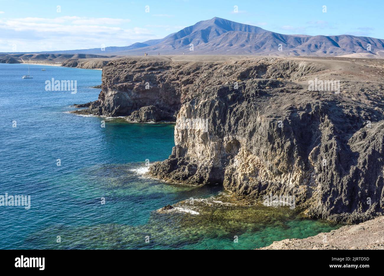 Cliffs of Playa Blanca with the Ajaches in the background Stock Photo