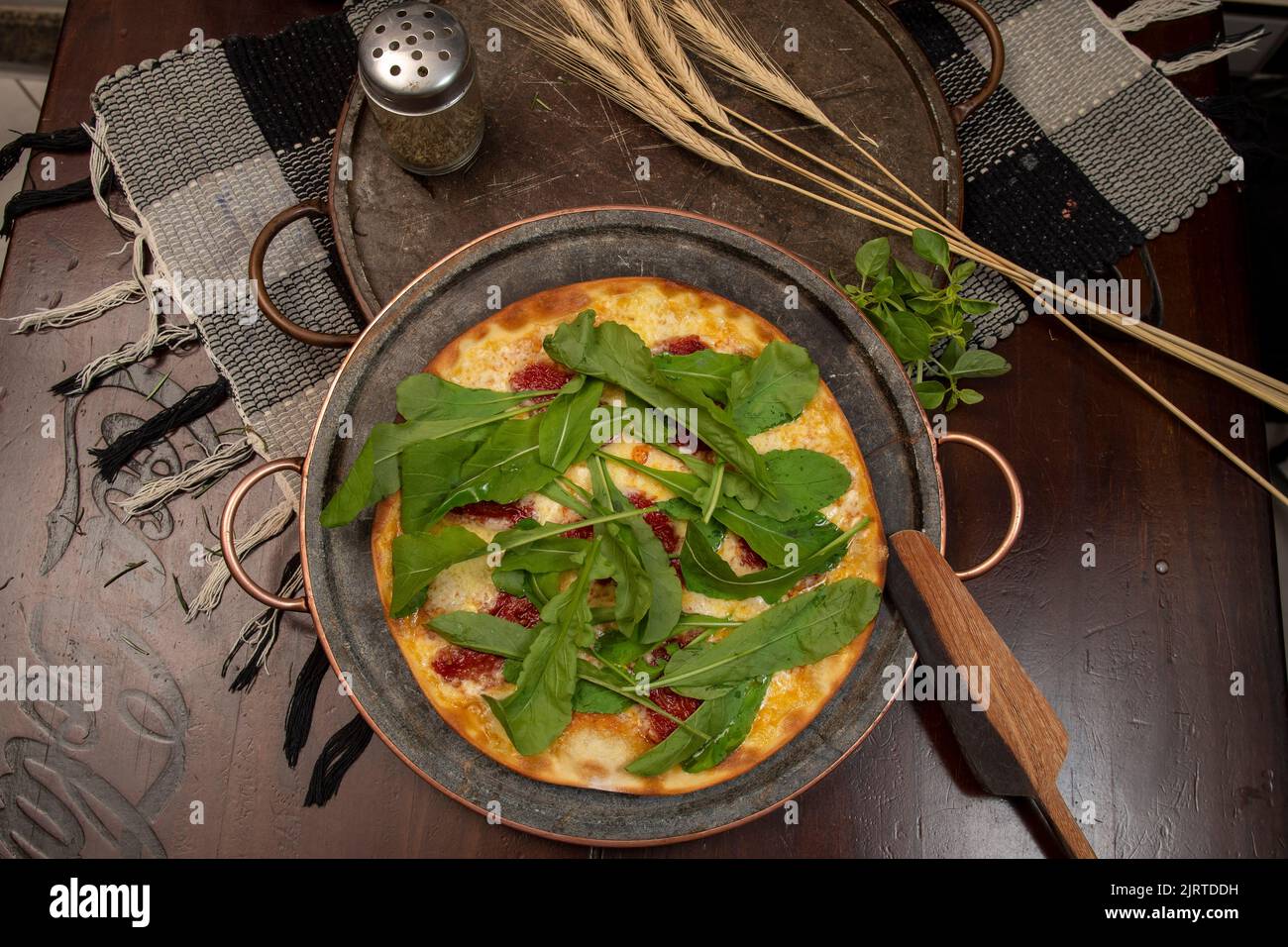 Brazilian pizza with sundried tomatoes, arugula and mozzarella