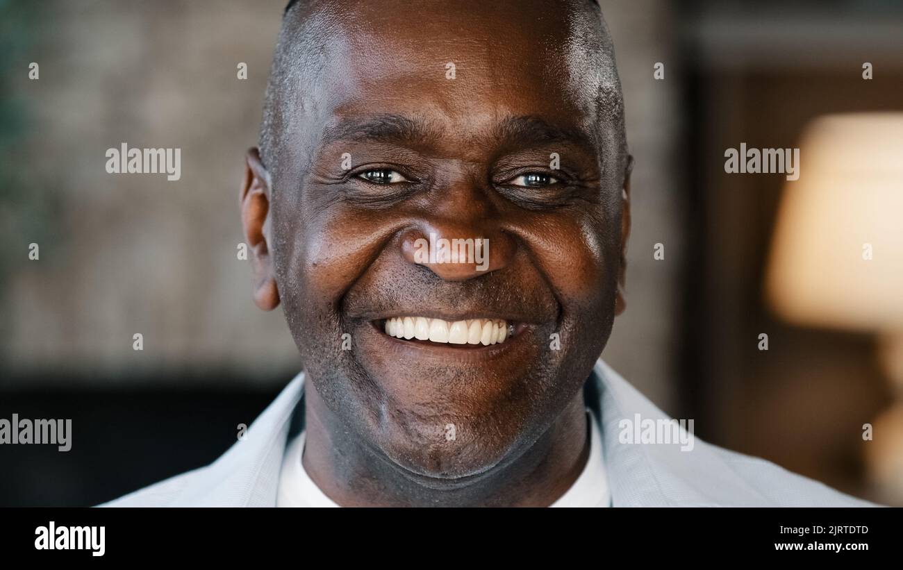 Happy emotional african american adult man sincere smiling laughing loud indoors head shot of mature senior pensioner grandpa laugh over humorous joke Stock Photo