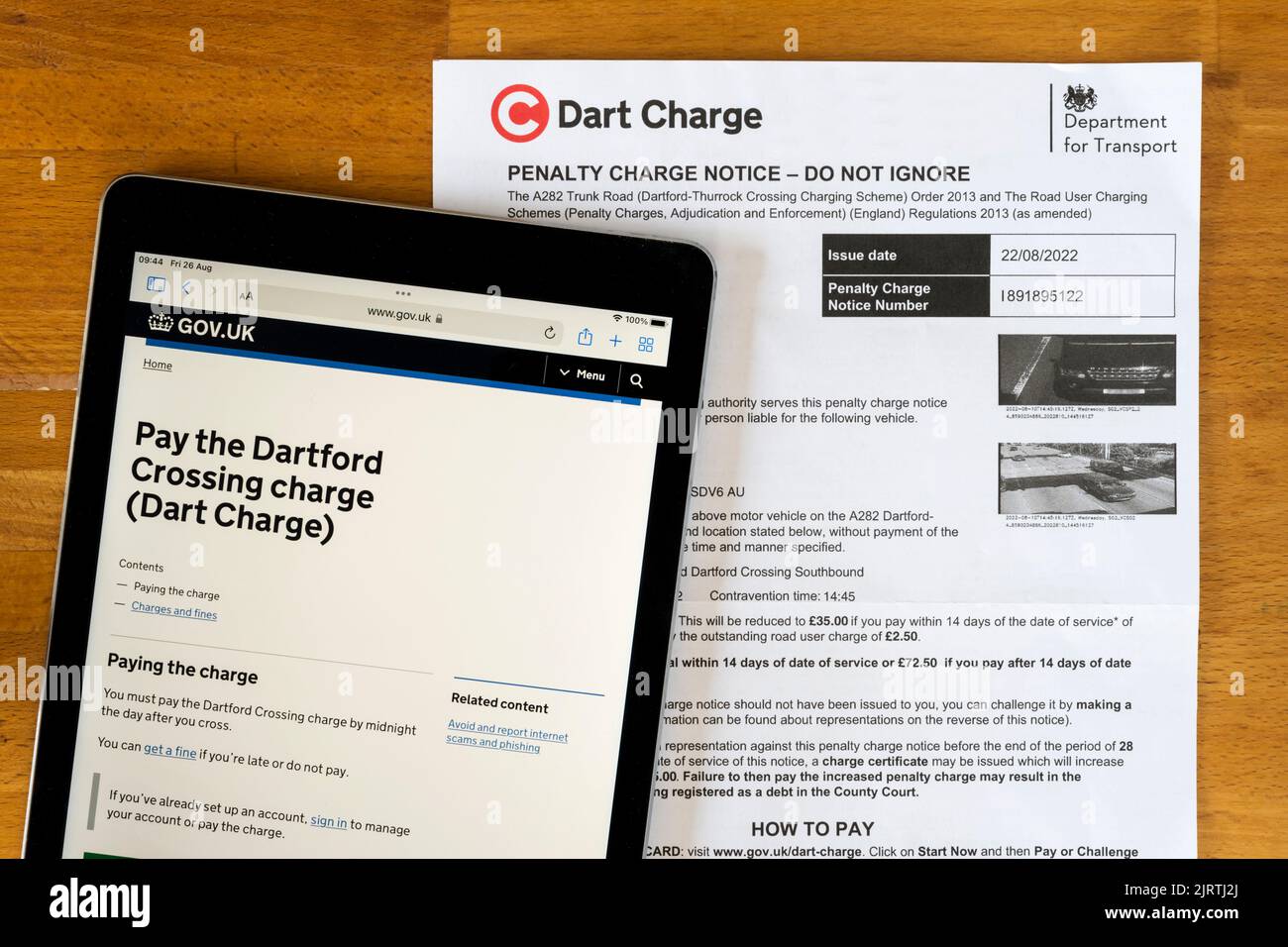 A Penalty Charge Notice for not paying the Dart Charge toll at the Dartford Thurrock Thames crossing. With payment website displayed on ipad. Stock Photo