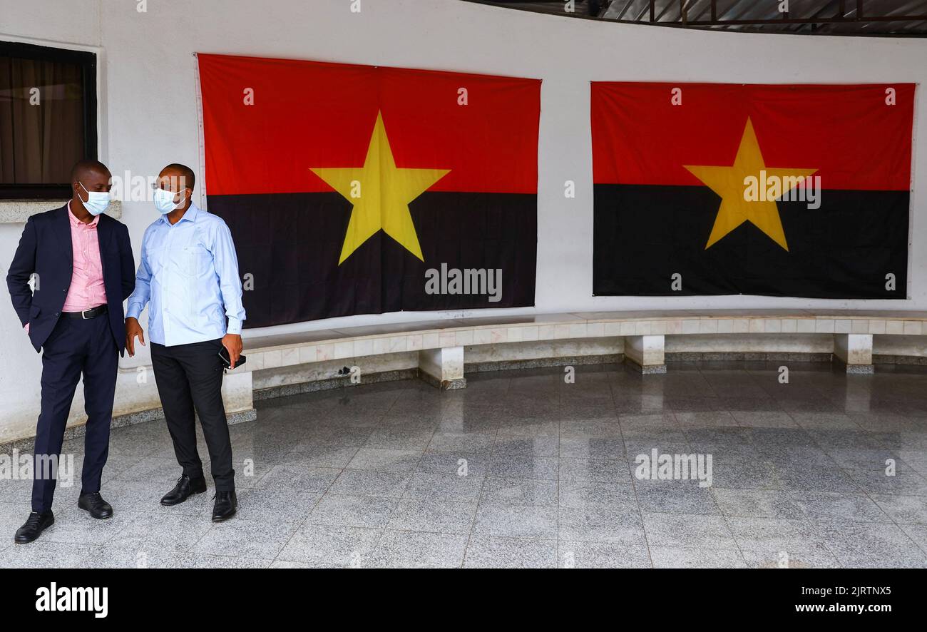 Officials chat next to the MPLA flags, after Angola's president and leader of the ruling MPLA Joao Lourenco left after a meeting at the party's headquarters in the capital Luanda, Angola August 26, 2022. REUTERS/Siphiwe Sibeko Stock Photo