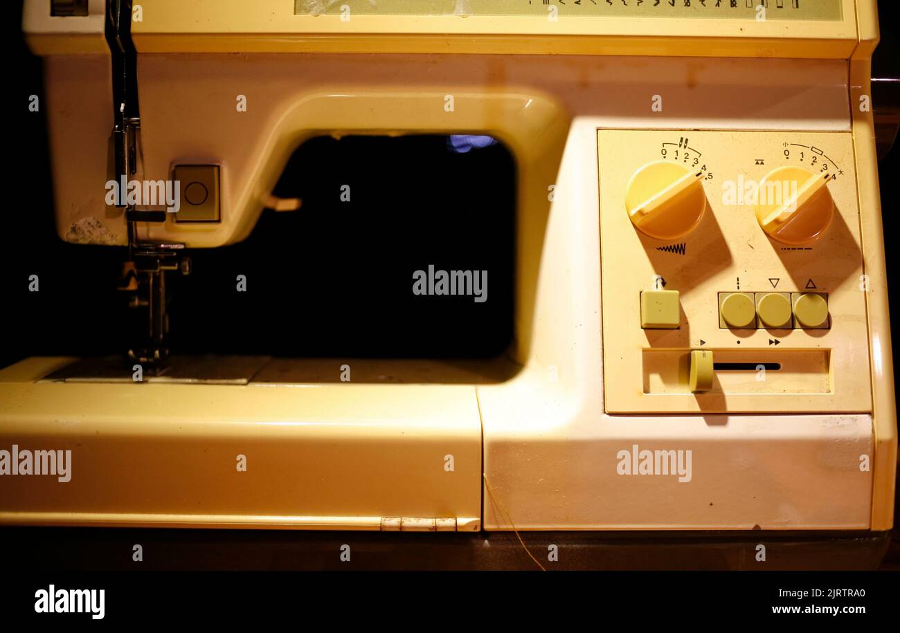 Sewing machine on table in tailor's workshop Stock Photo