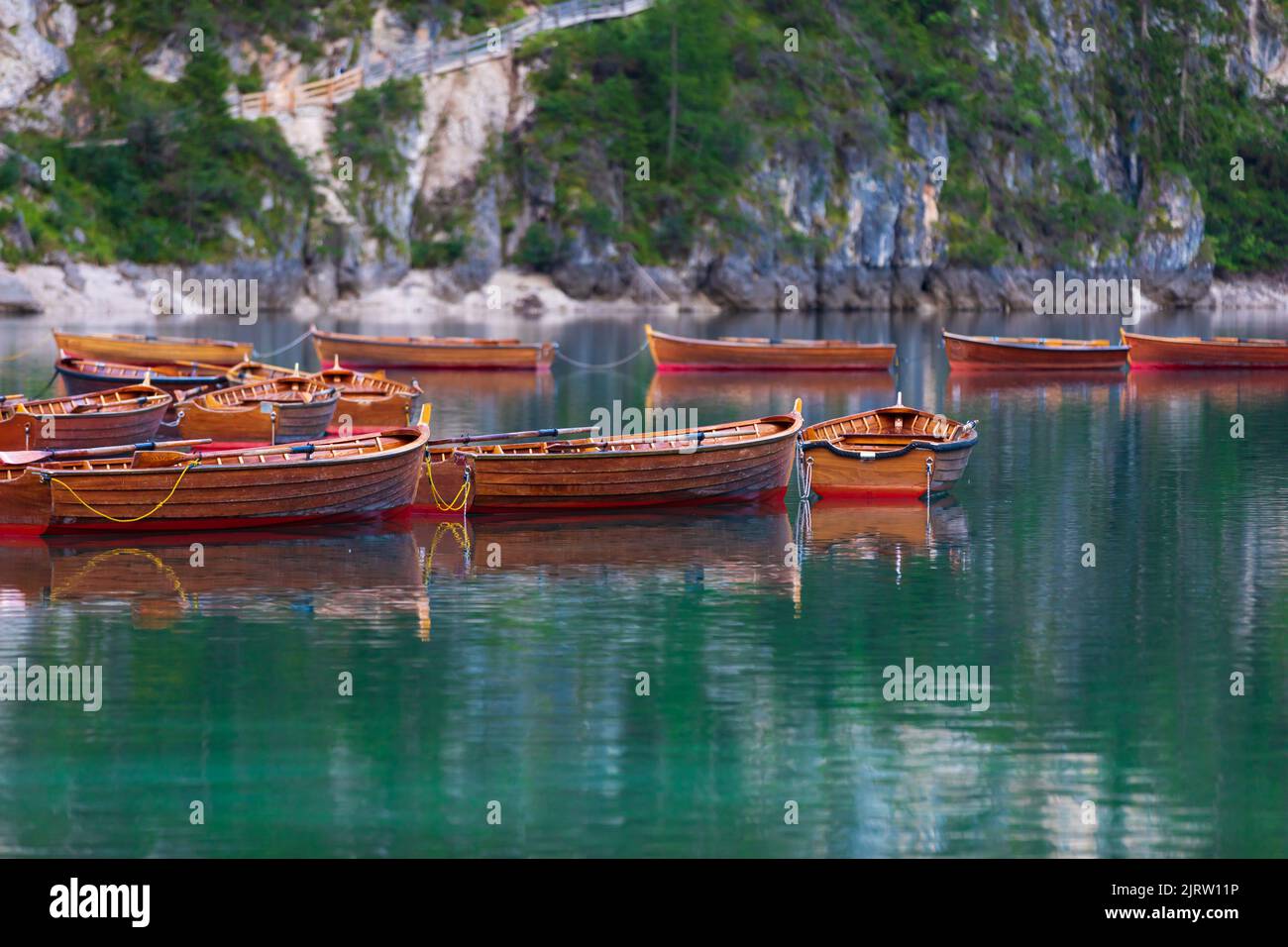 quaint and picturesque wooden boats in a lake in the alpine mountains in the middle of the Dolomites Stock Photo