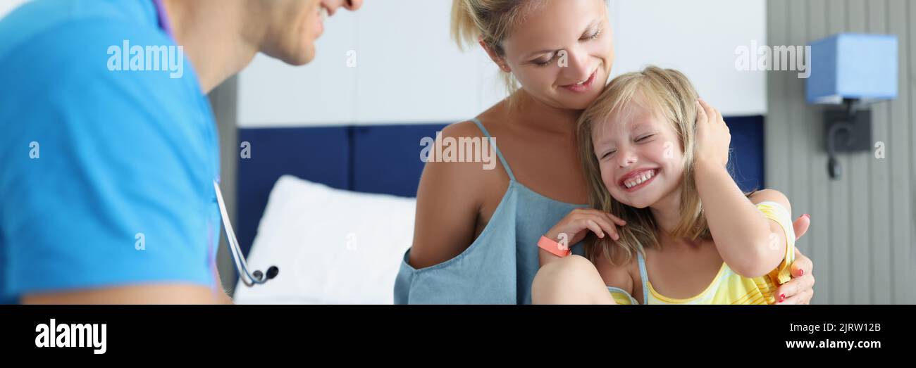Doctor communicates with child and mother in hotel rooms Stock Photo