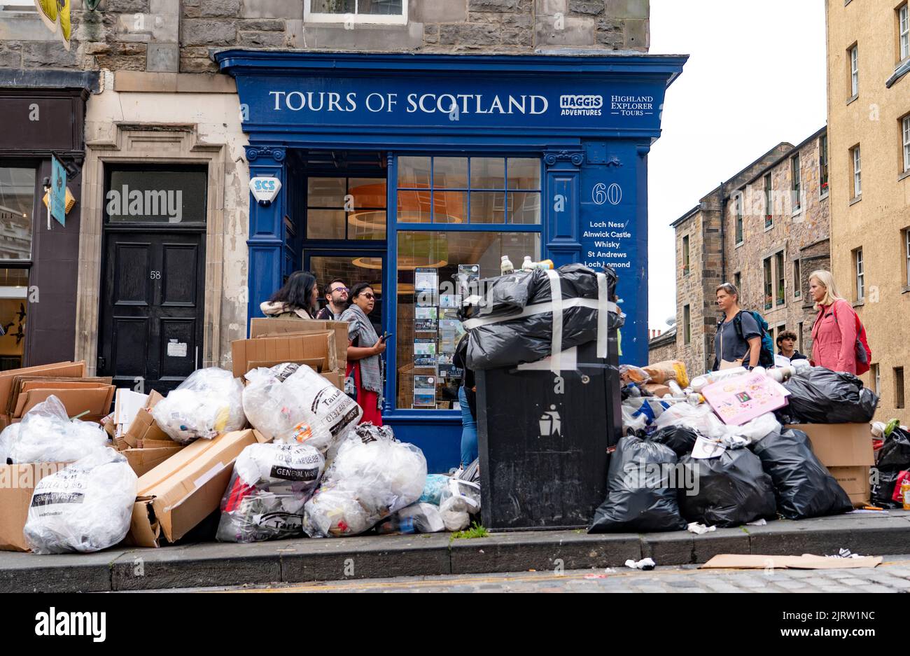 Edinburgh, Scotland, UK. 26th August 2022. Rubbish is seen piled on streets and beside many overflowing bins in Edinburgh City Centre today. The Binmen’s strike continues in Edinburgh and today strikes are extended to include Glasgow, Aberdeen and Dundee. Piles of Rubbish outside tourist travel shop.  Iain Masterton/Alamy Live News Stock Photo