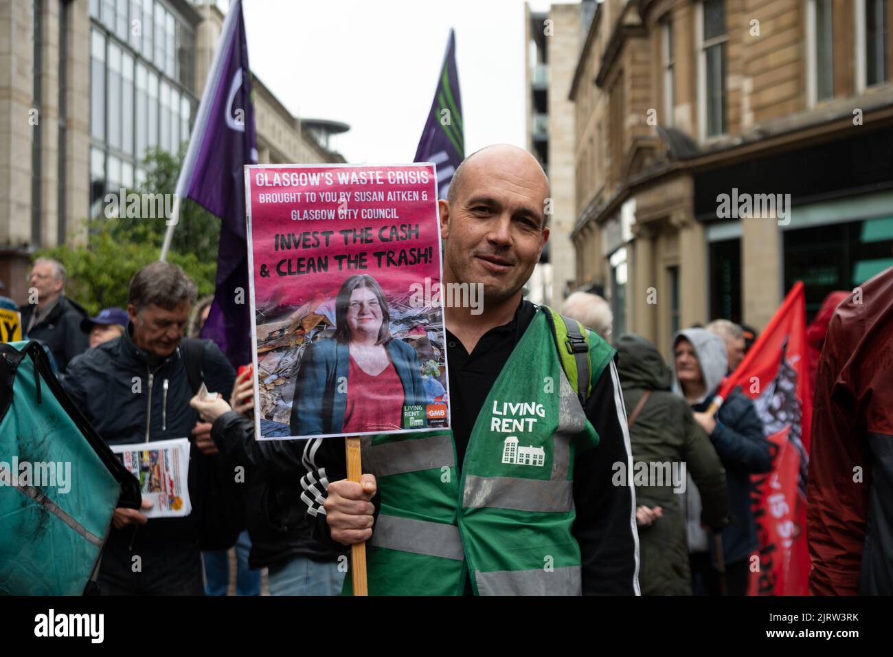 Glasgow, Scotland, UK. 26th Aug, 2022. Joint union Strike Rally in Glasgow city centre.  Pictured: person holding a combined Living Rent (Scotland's tenants union) and GMB Scotland placard asking for Glasgow's cleansing services to receive increased funding.  'Invest the Cash and Clean the Trash'  Credit: Kay Roxby/Alamy Live News Stock Photo