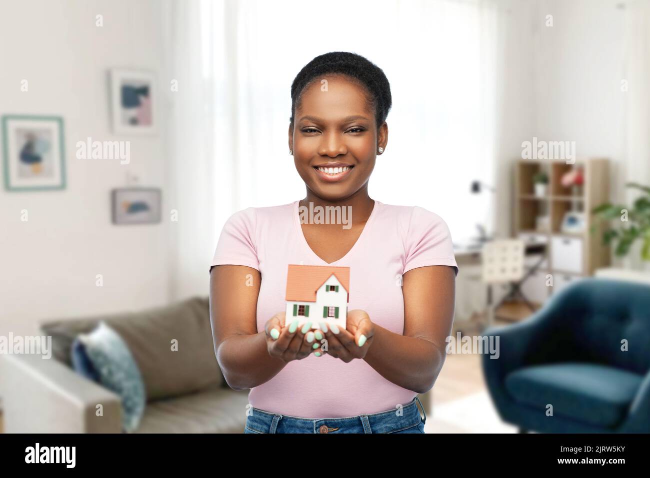 smiling african american woman holding house model Stock Photo - Alamy
