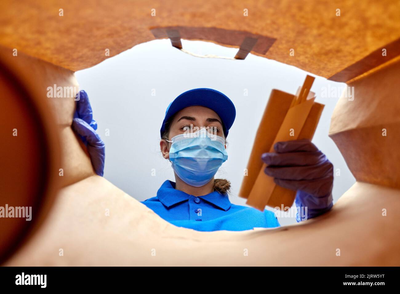 delivery girl in gloves and mask with food in bag Stock Photo - Alamy