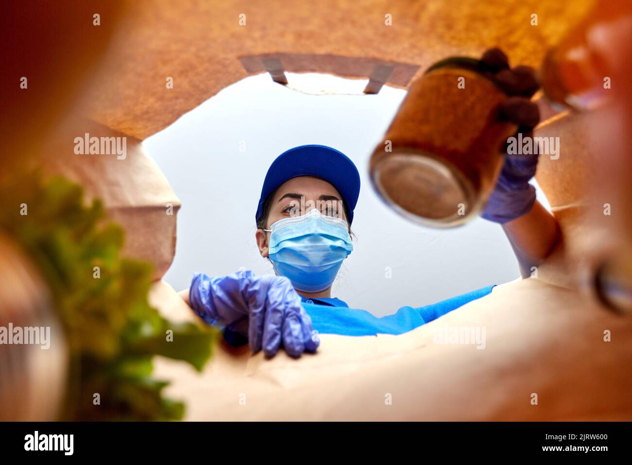 delivery girl in gloves and mask with food in bag Stock Photo - Alamy