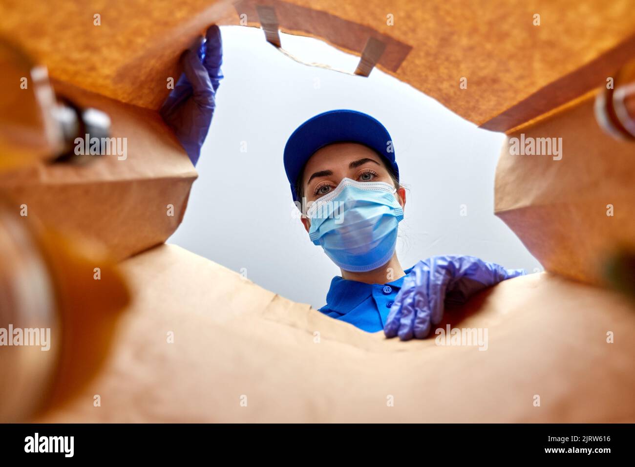 delivery girl in gloves and mask with food in bag Stock Photo - Alamy