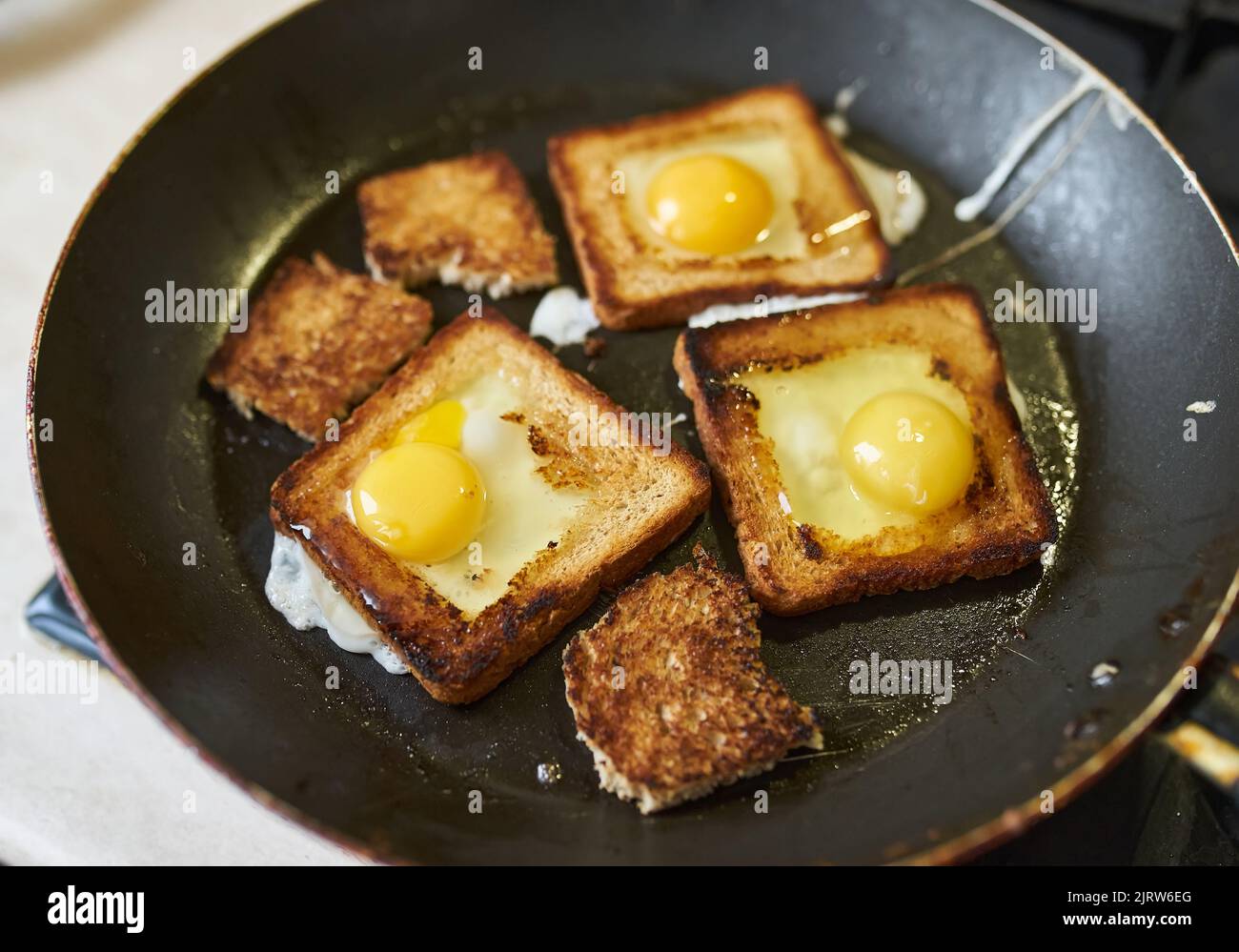 Cooking croutons with an egg inside, croutons are fried in a pan on a